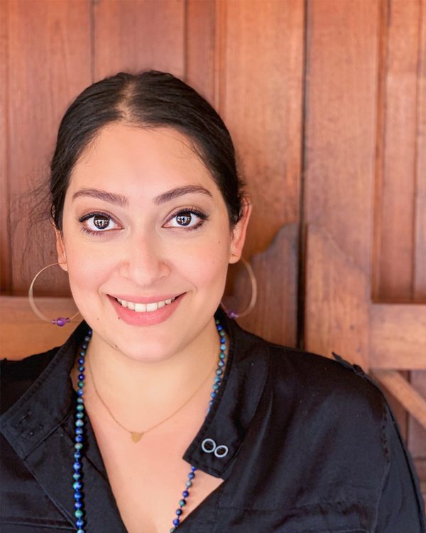 Christabel Lobo smiling in front of a wooden door